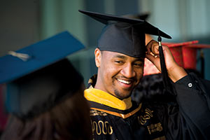 A male student tips his hat at a UC Davis commencement ceremony