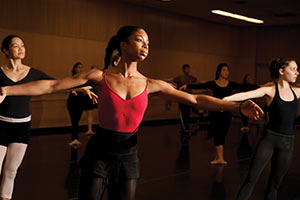 A group of students practice ballet in a dance studio